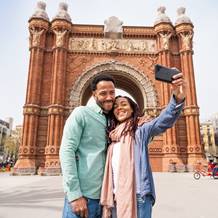 Feliz pareja haciendo un selfie cerca del Arco de Triunfo de Barcelona