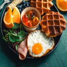 waffles con huevo frito, frutas y jamón