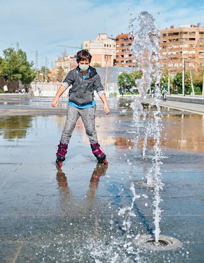 patinar sobre el agua | VAMOS.BARCELONA | Qué hacer en Barcelona hoy Niño con máscara y patines, patinando sobre el agua en la fuente del parque
