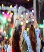 Heart shaped hands at concert. Music concert with lights and silhouette of people enjoying concert.